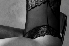 Zwart-wit boudoirfoto met focus op silhouet en vormen.